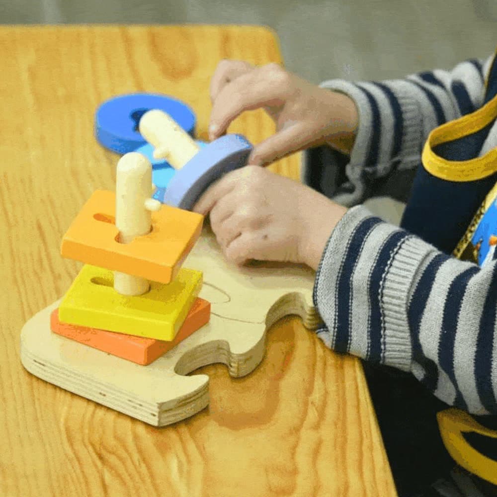 Niño encajando piezas de madera por forma y color