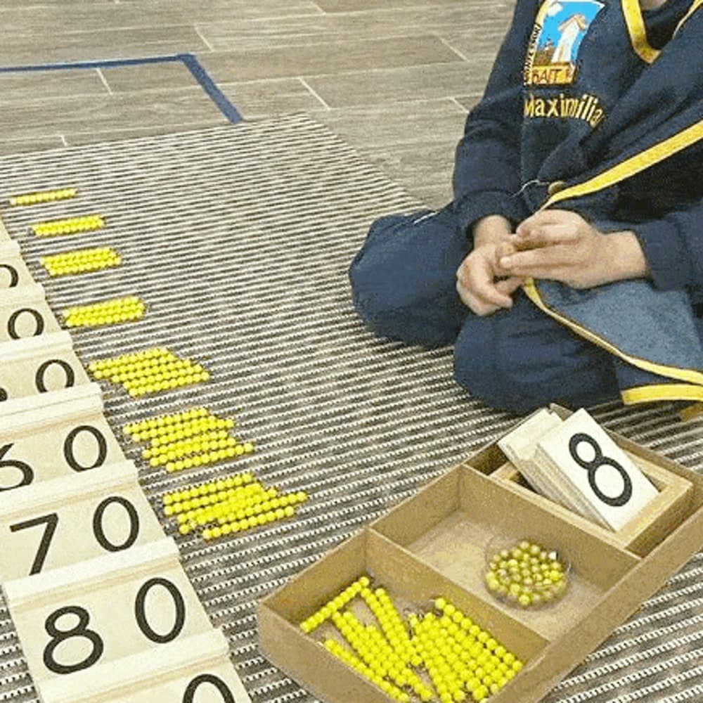 Tabla numérica con las perlas doradas del material de matemáticas