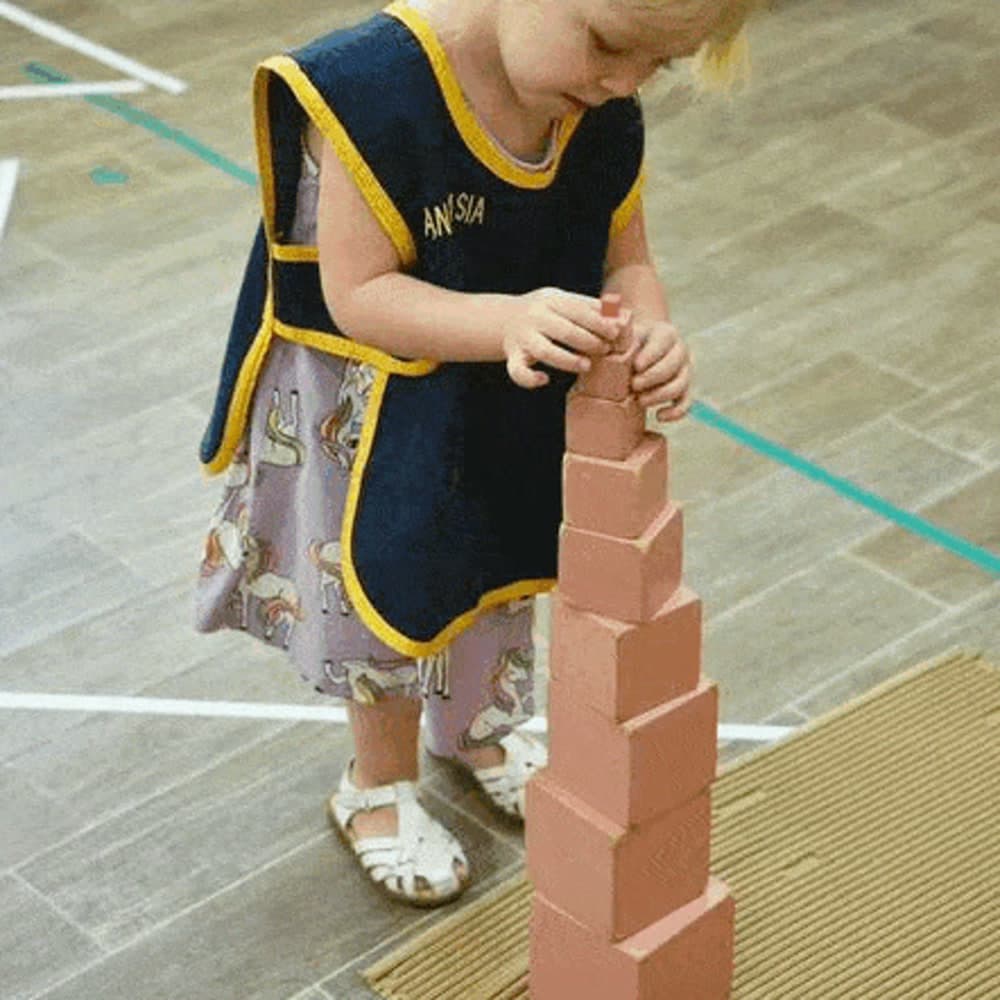 Niña apilando la torre rosa, material sensorial Montessori