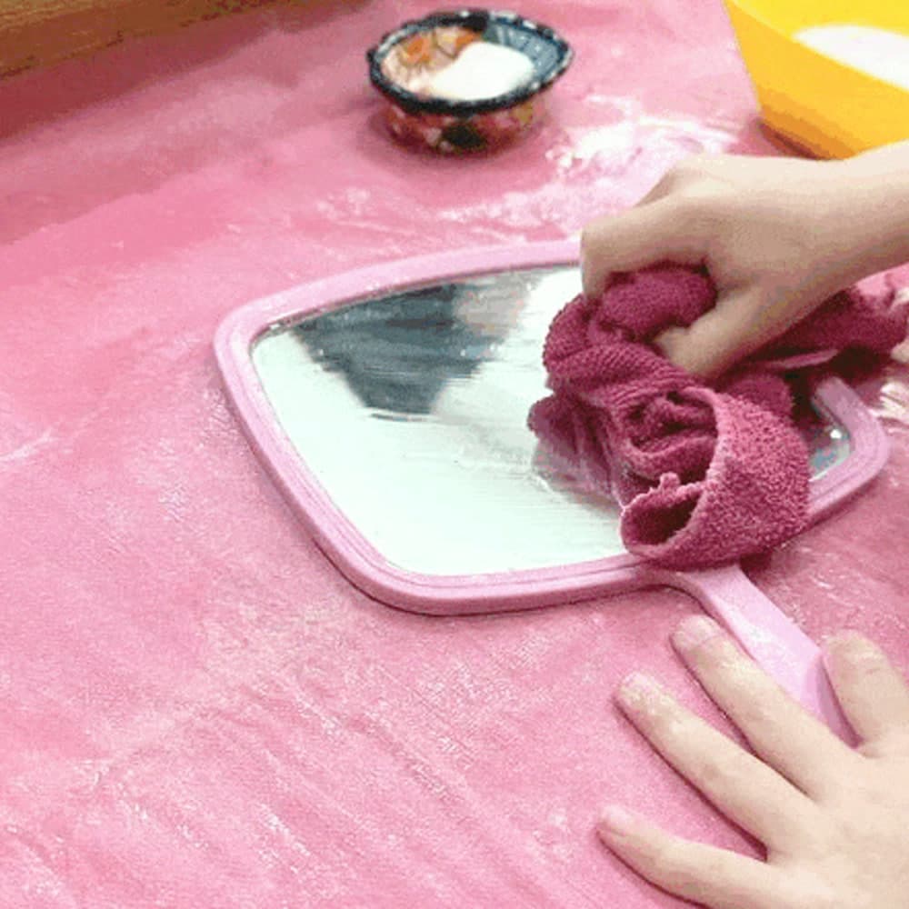 Manos de un niño puliendo una bandeja con un paño