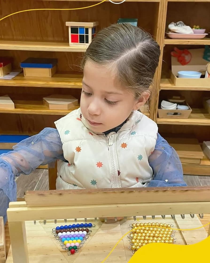 Niño trasvasando agua con un embudo en el ambiente Montessori