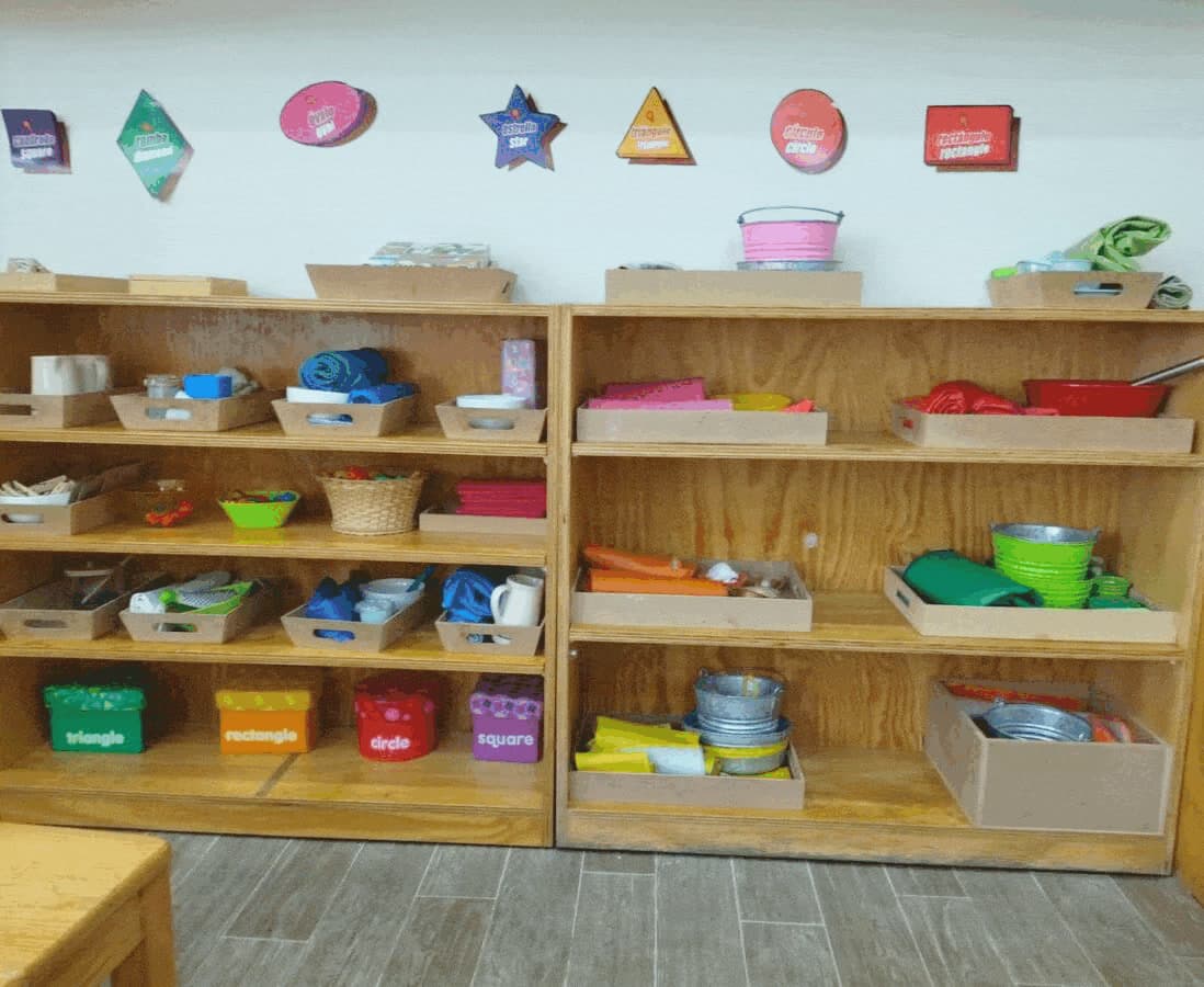 Estantes con el material Montessori clasificado por áreas