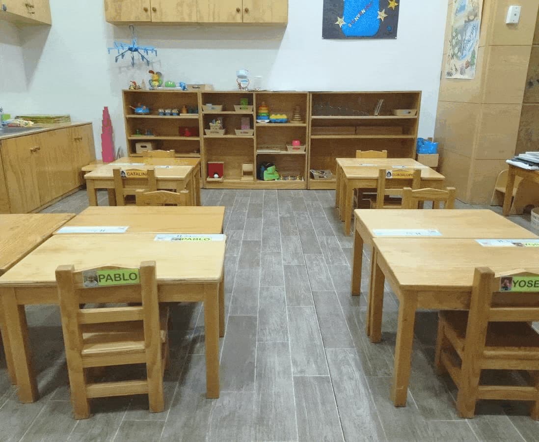 Salón Montessori con mesas y sillas a la altura de los niños