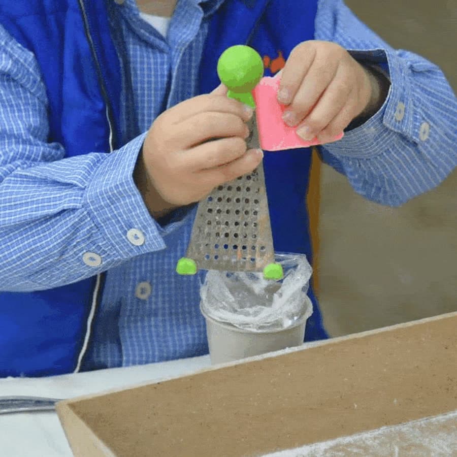 Niño rallando jabón en la mesa de vida práctica