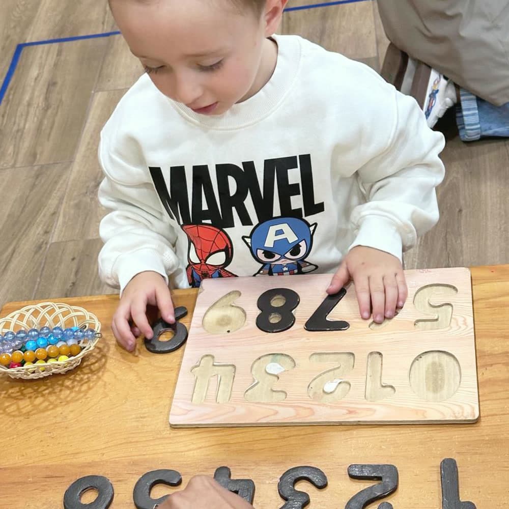 Niño encajando las cifras del uno al nueve en su tablero